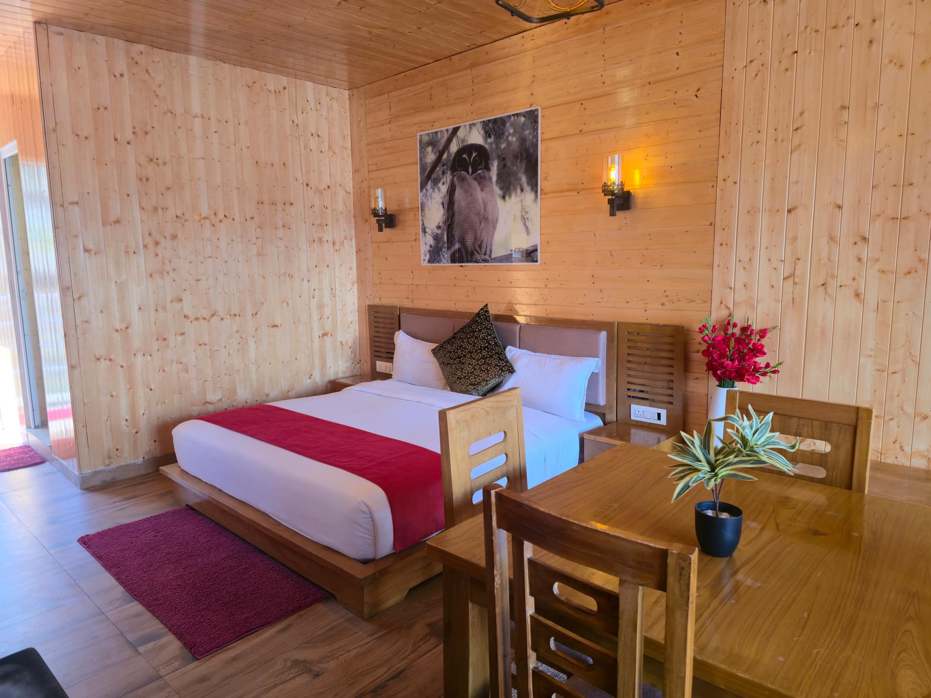 Wooden resort room with bed, dining table and warm interior